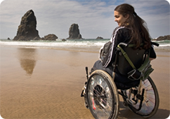 Young woman in wheelchair enjoying scenery at the beach
